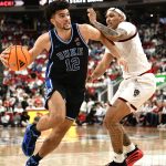 Cameron Boozer drives the ball around NC State Wolfpack forward Darrion Williams.