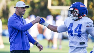 Florida coach Jon Sumrall fist-bumps linebacker Myles Johnson.