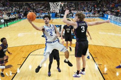 Duke Blue Devils guard Cayden Boozer shoots as Texas Christian University Horned Frogs guard Liutauras Lelevicius defends.