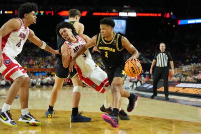 Michigan Wolverines guard Trey McKenney drives to the basket against Arizona Wildcats guard Anthony Dell'orso.