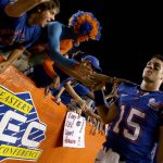 Tim Tebow celebrates with fans after a game.