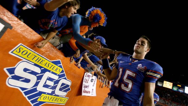 Tim Tebow celebrates with fans after a game.