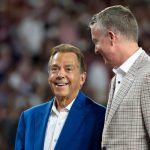 Nick Saban and Greg Byrne speak during an Alabama football game.