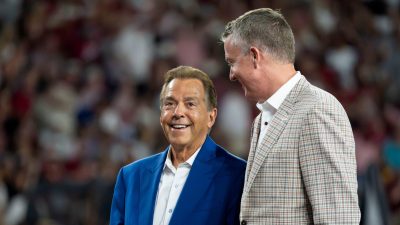 Nick Saban and Greg Byrne speak during an Alabama football game.