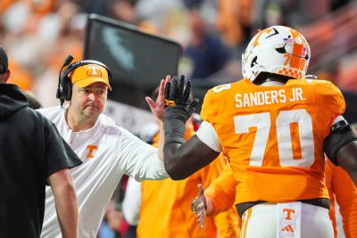 Josh Heupel high-fives a Tennessee player.