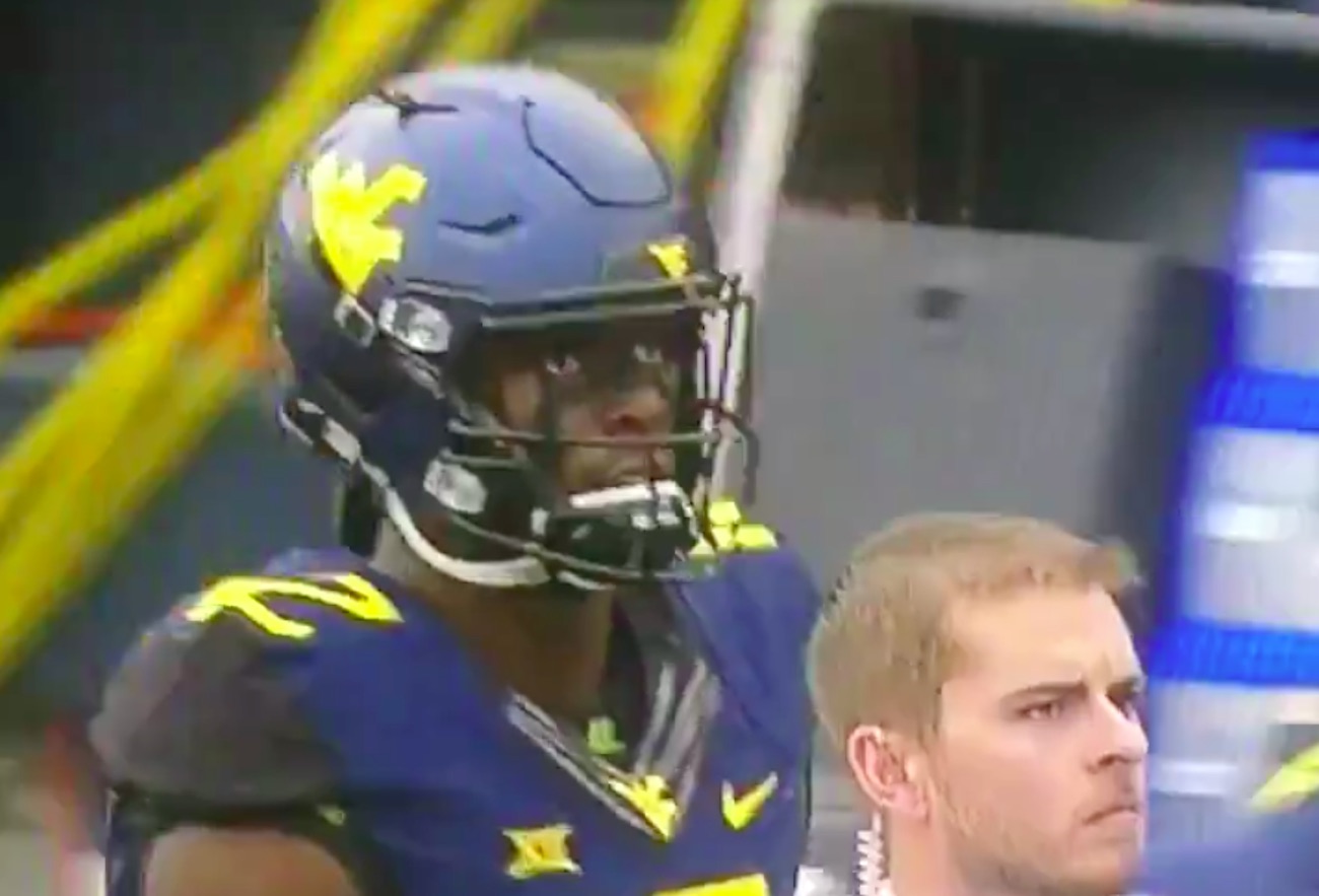 WATCH West Virginia player has bird feathers in his helmet during game
